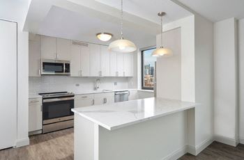 White kitchen with marble island and pendant lighting